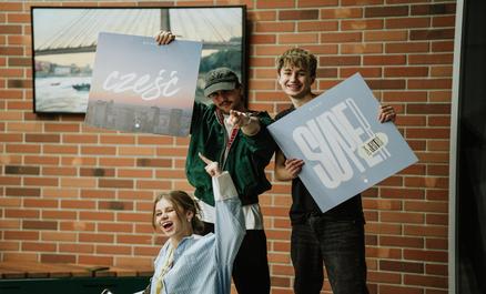 Grupa młodych ludzi z plakatami.